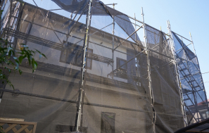 建物全体を覆う足場と養生シートの写真